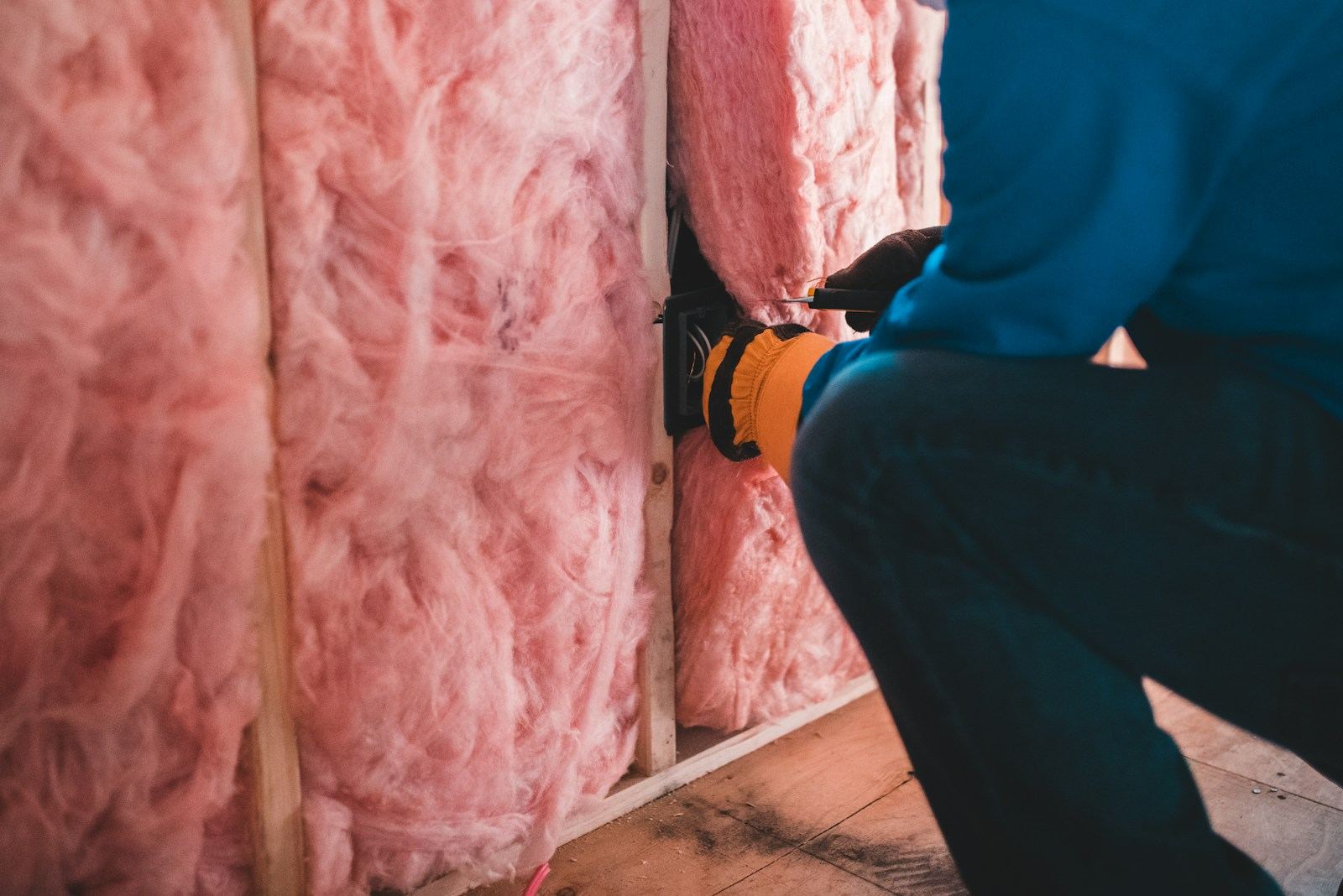 Insulation being fitted into a stud wall during a home remodel